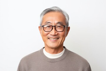 Fototapeta premium medium shot portrait of a happy Japanese man in his 60s wearing a chic cardigan against a white background