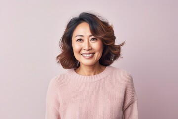 Fototapeta premium medium shot portrait of a happy Japanese woman in her 40s wearing a cozy sweater against a pastel or soft colors background