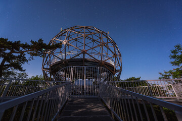 Balatonboglar lookout tower or Xantus Janos sphere viewpoint at night, scenic view of the spherical construction and blue sky with stars, outdoor travel background, Balaton lake, Hungary - 649726662