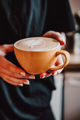 Woman barista hands holding cup of hot coffee latte cappuccino