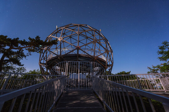 Balatonboglar lookout tower or Xantus Janos sphere viewpoint at night, scenic view of the spherical construction and blue sky with stars, outdoor travel background, Balaton lake, Hungary