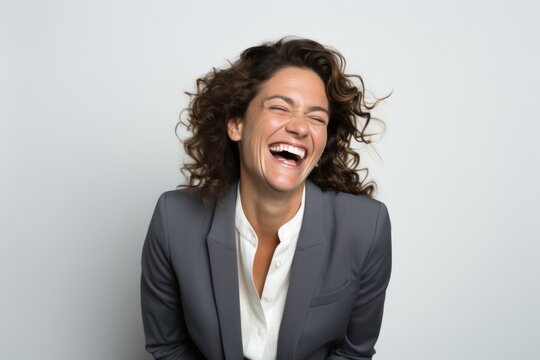 portrait of a happy Israeli woman in her 40s wearing a classic blazer against a white background