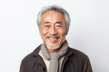 portrait of a happy Japanese man in his 60s wearing a foulard against a white background