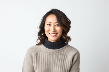 Obraz premium portrait of a happy Japanese woman in her 30s wearing a cozy sweater against a white background