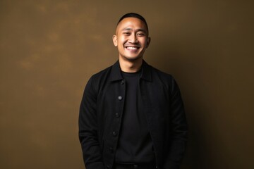 Obraz premium medium shot portrait of a Filipino man in his 30s wearing a chic cardigan against an abstract background