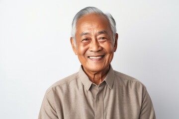 medium shot portrait of a Filipino man in his 70s wearing a chic cardigan against a white background