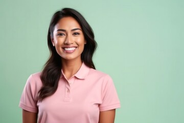 medium shot portrait of a Filipino woman in her 30s wearing a sporty polo shirt against a pastel or soft colors background