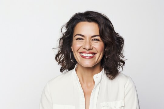 portrait of a happy Mexican woman in her 40s wearing a chic cardigan against a white background
