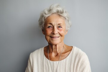 portrait of a happy Polish woman in her 80s wearing a chic cardigan against a minimalist or empty room background