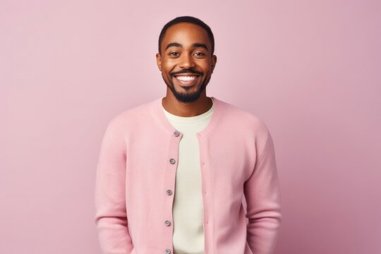 medium shot portrait of a Kenyan man in his 20s wearing a chic cardigan against a pastel or soft colors background