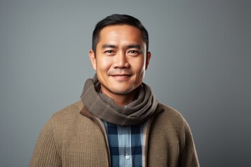 portrait of a Filipino man in his 40s wearing a foulard against a minimalist or empty room background