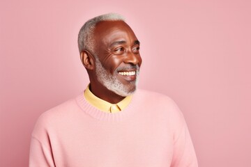 medium shot portrait of a Kenyan man in his 60s wearing a chic cardigan against a pastel or soft colors background