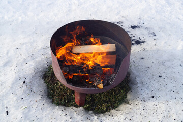 bonfire in the snow, burning campfire with firewood 