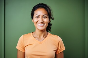Fototapeta premium portrait of a Filipino woman in her 30s wearing a sporty polo shirt against an abstract background