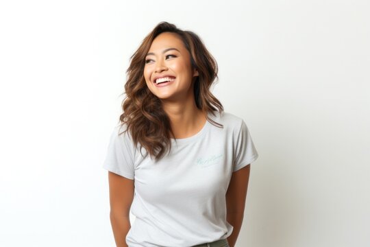portrait of a Filipino woman in her 30s wearing a fun graphic tee against a white background
