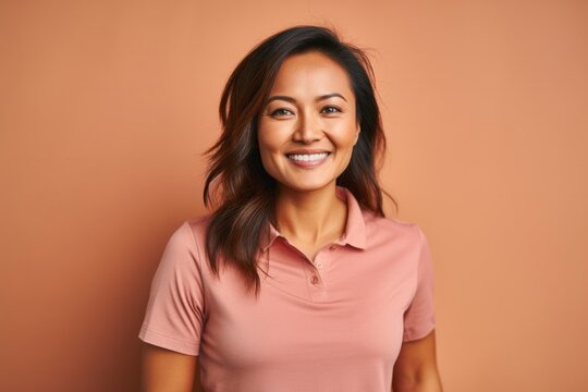 portrait of a Filipino woman in her 30s wearing a sporty polo shirt against an abstract background