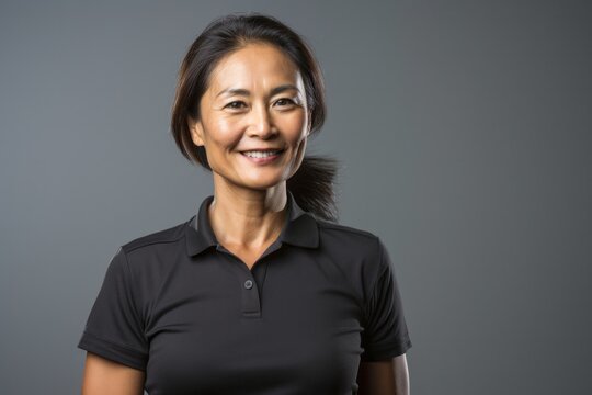 portrait of a Filipino woman in her 40s wearing a sporty polo shirt against a white background