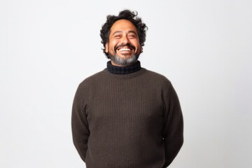medium shot portrait of a Mexican man in his 40s wearing a cozy sweater against a white background