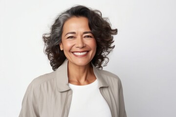 medium shot portrait of a Mexican woman in her 50s wearing a chic cardigan against a white background