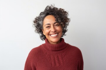 medium shot portrait of a Mexican woman in her 50s wearing a cozy sweater against a white background