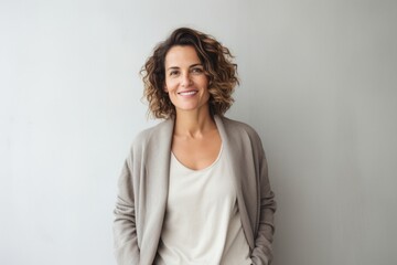 Fototapeta premium portrait of a Israeli woman in her 40s wearing a chic cardigan against a minimalist or empty room background