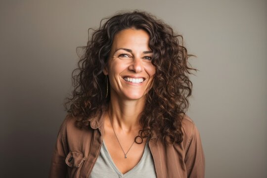 portrait of a Israeli woman in her 40s wearing a chic cardigan against a minimalist or empty room background