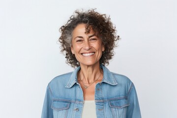 portrait of a Israeli woman in her 50s wearing a denim jacket against a white background - obrazy, fototapety, plakaty