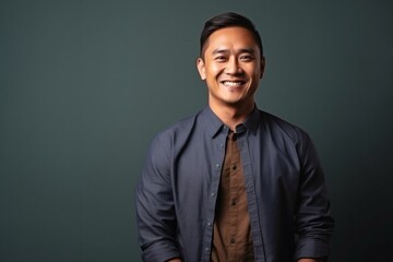 Obraz premium medium shot portrait of a confident Filipino man in his 30s wearing a chic cardigan against an abstract background