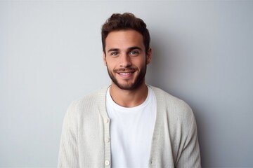 medium shot portrait of a confident Israeli man in his 20s wearing a chic cardigan against a minimalist or empty room background - obrazy, fototapety, plakaty