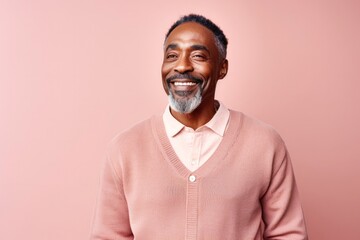 portrait of a Kenyan man in his 40s wearing a chic cardigan against a pastel or soft colors background