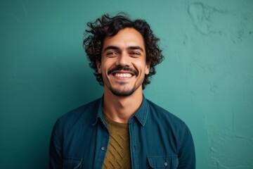 Fototapeta premium portrait of a Mexican man in his 30s wearing a chic cardigan against an abstract background