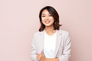 medium shot portrait of a confident Japanese woman in her 30s wearing a chic cardigan against a pastel or soft colors background