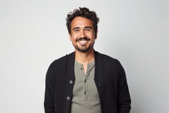 portrait of a Mexican man in his 30s wearing a chic cardigan against a white background
