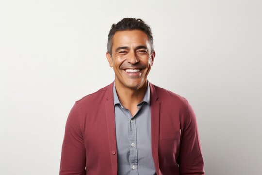 portrait of a Mexican man in his 40s wearing a chic cardigan against a white background