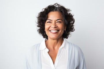 portrait of a Mexican woman in her 50s wearing a chic cardigan against a white background