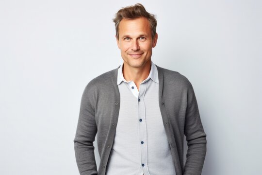 portrait of a Polish man in his 40s wearing a chic cardigan against a white background
