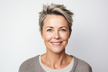portrait of a Polish woman in her 40s wearing a chic cardigan against a white background - obrazy, fototapety, plakaty