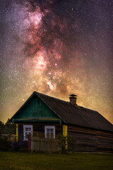 A farm house on the background of The Milky Way in the countryside at night in summer 