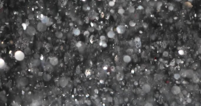 Silver glitter background with blets. Shiny texture and holiday lights and flying particles form beautiful bokeh