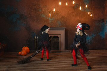 Little witches sit on brooms, run around the room one after another, and play.