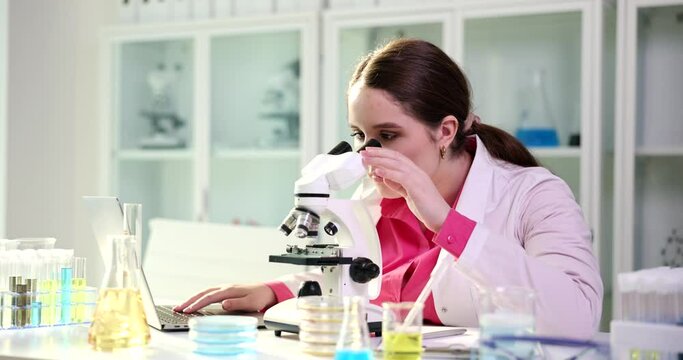 Scientist or student using laptop computer and microscope. Science future and forensic laboratory