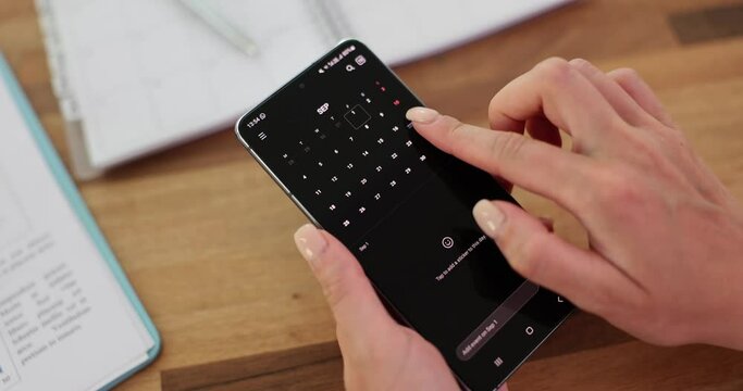 Closeup of a woman using calendar application on mobile device. Scrolling through the year calendar screen on smartphone