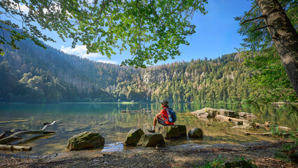 nice senior woman resting during a  mountain bike tour at Lake Feldsee in the  German Black Forest...