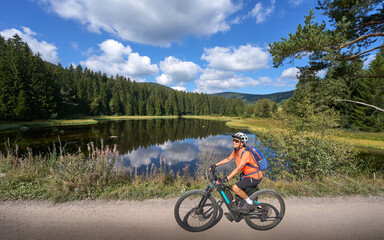 nice senior woman on her electric mountain bike cycling at Lake Schluchsee in the German Black...