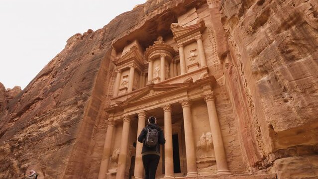 Hiker walking towards the Treasury of Petra - UNESCO World Heritage site.
