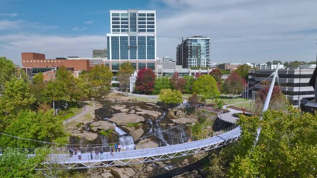 Aerial view of Reedy River Waterfalls in downtown of Greenville city in South Carolina. Falls Park riverwalk at Liberty bridge. American travel destination