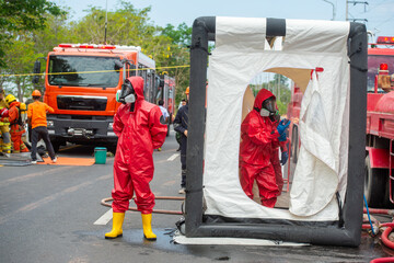 Rescuers wearing red hazmat suits assembled a Inflatable sterilization tunnel tentst. To be used in...