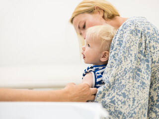 child beeing vaccinated by pediatrician in presence of his mother. Preventive vaccination against...