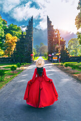 Woman walking at big entrance gate, Bali in Indonesia. - obrazy, fototapety, plakaty
