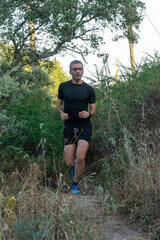 Experienced trail runner with gray hair and sleek black gear, conquering rugged terrain.